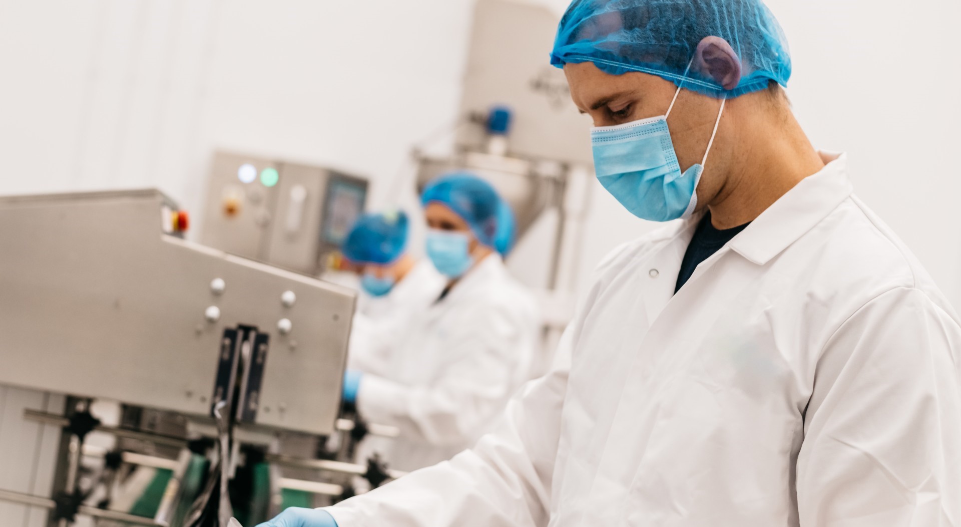 A man in a lab coat working on a laptop.