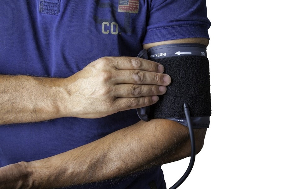 A person wearing a blood pressure cuff on their upper arm.